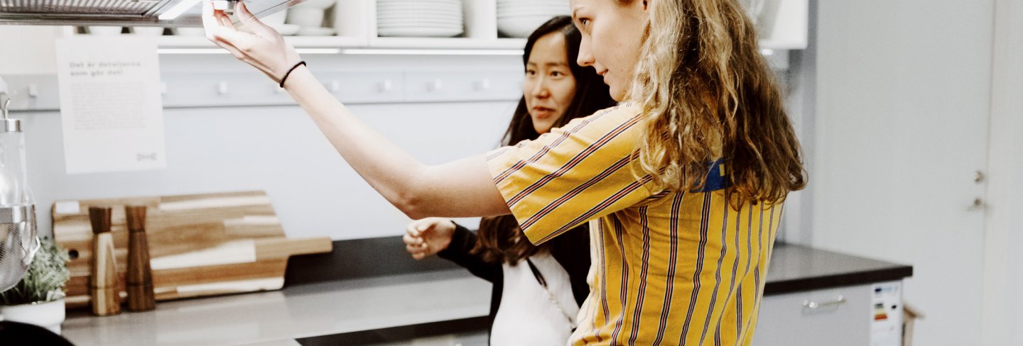 Woman getting help from IKEA employee in the kitchen department.