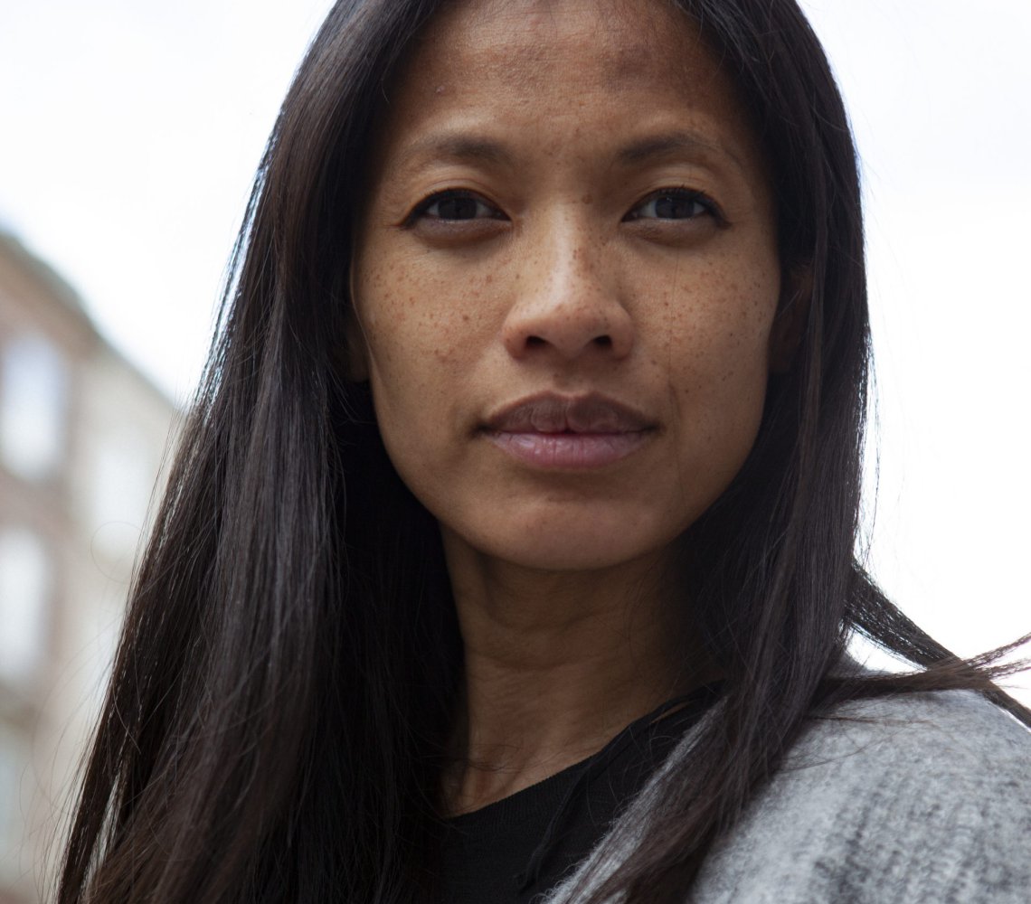 Woman standing outside, with a warm how ever determined look on her face.