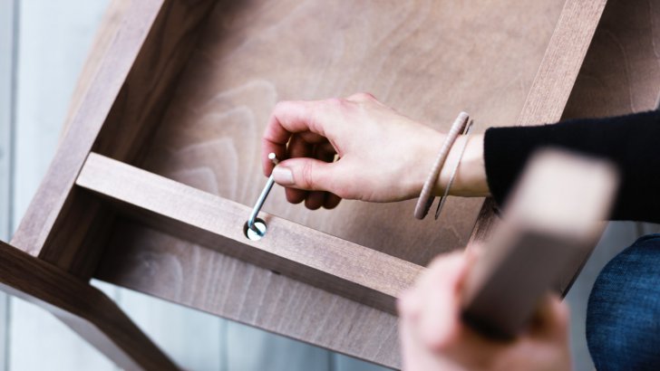 Woman assembling a chair with an allen key.
