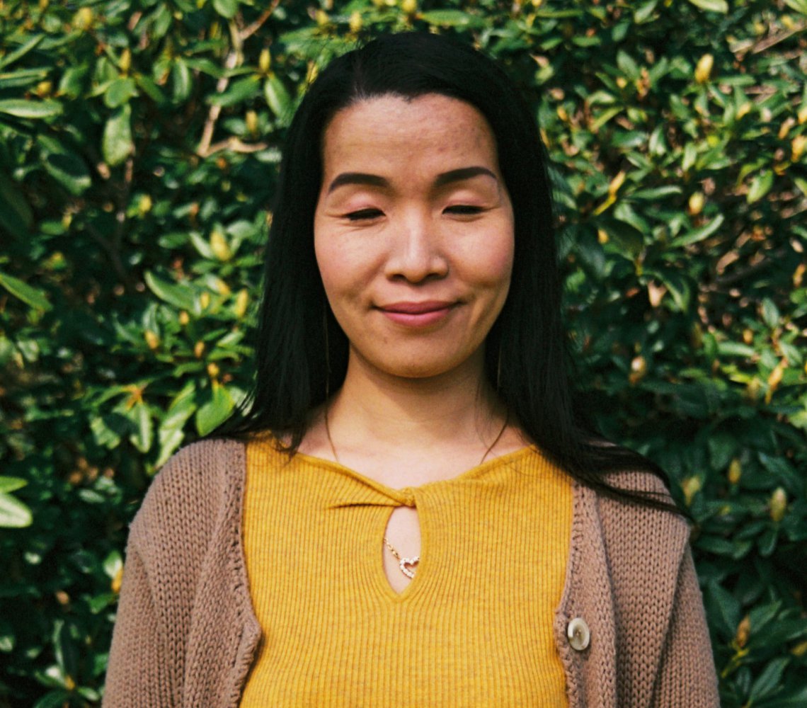 Woman with a smile on her face, closing her eyes.