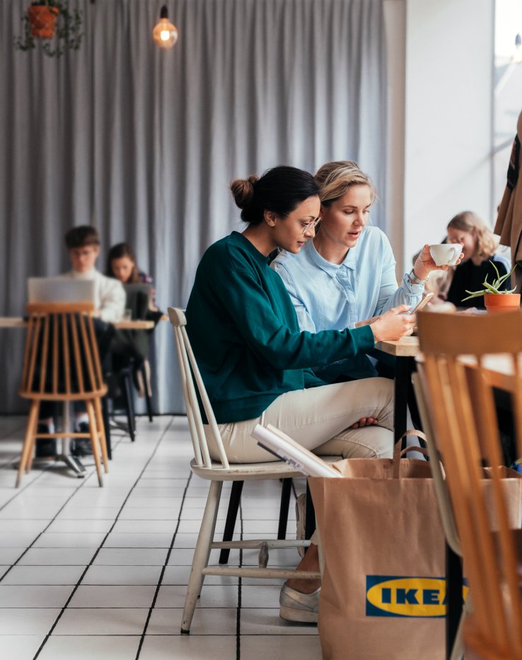 Two friends enjoying a cup of coffe together after shopping at IKEA.