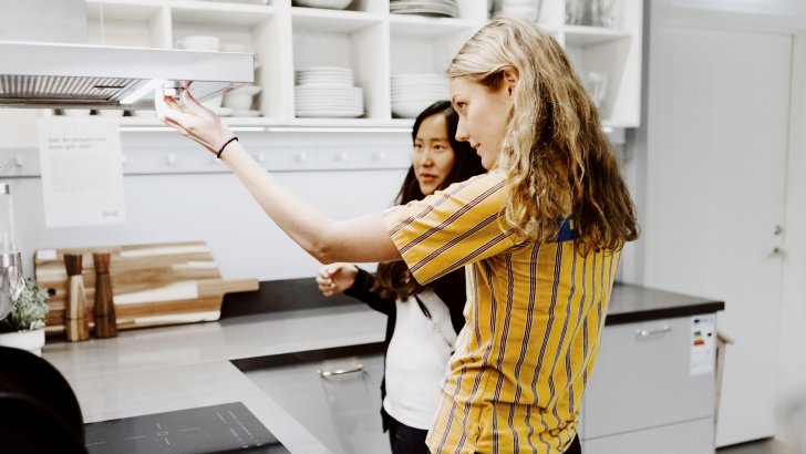 Woman getting help from IKEA employee in the kitchen department.